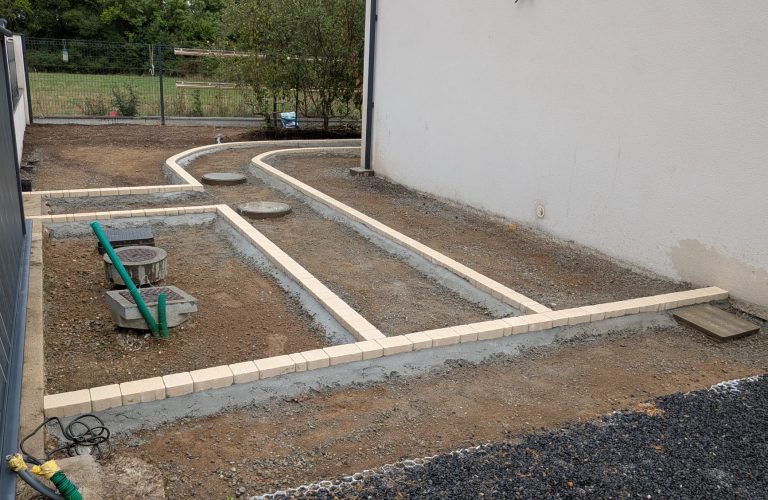 Pavage beige pour délimiter l'allée et les végétaux