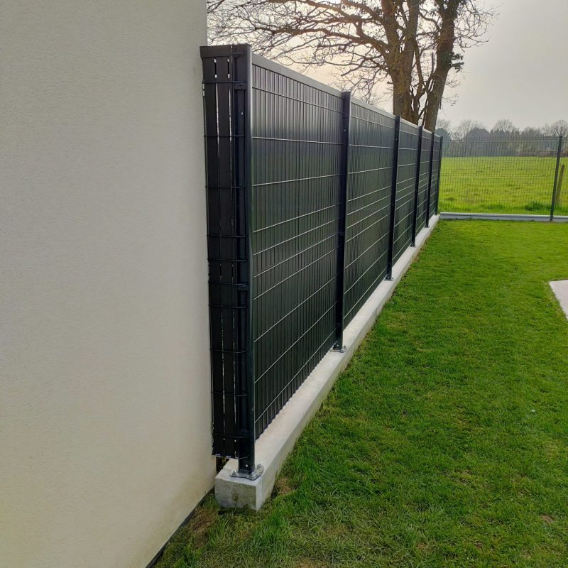 Pose d'une clôture rigide sur un mur de soutènement en parpaings